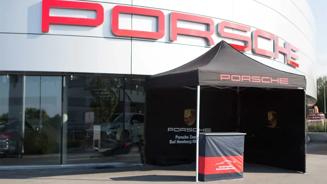 Bedrucktes schwarzes Faltzelt als Eventstand vor einem Porsche-Zentrum