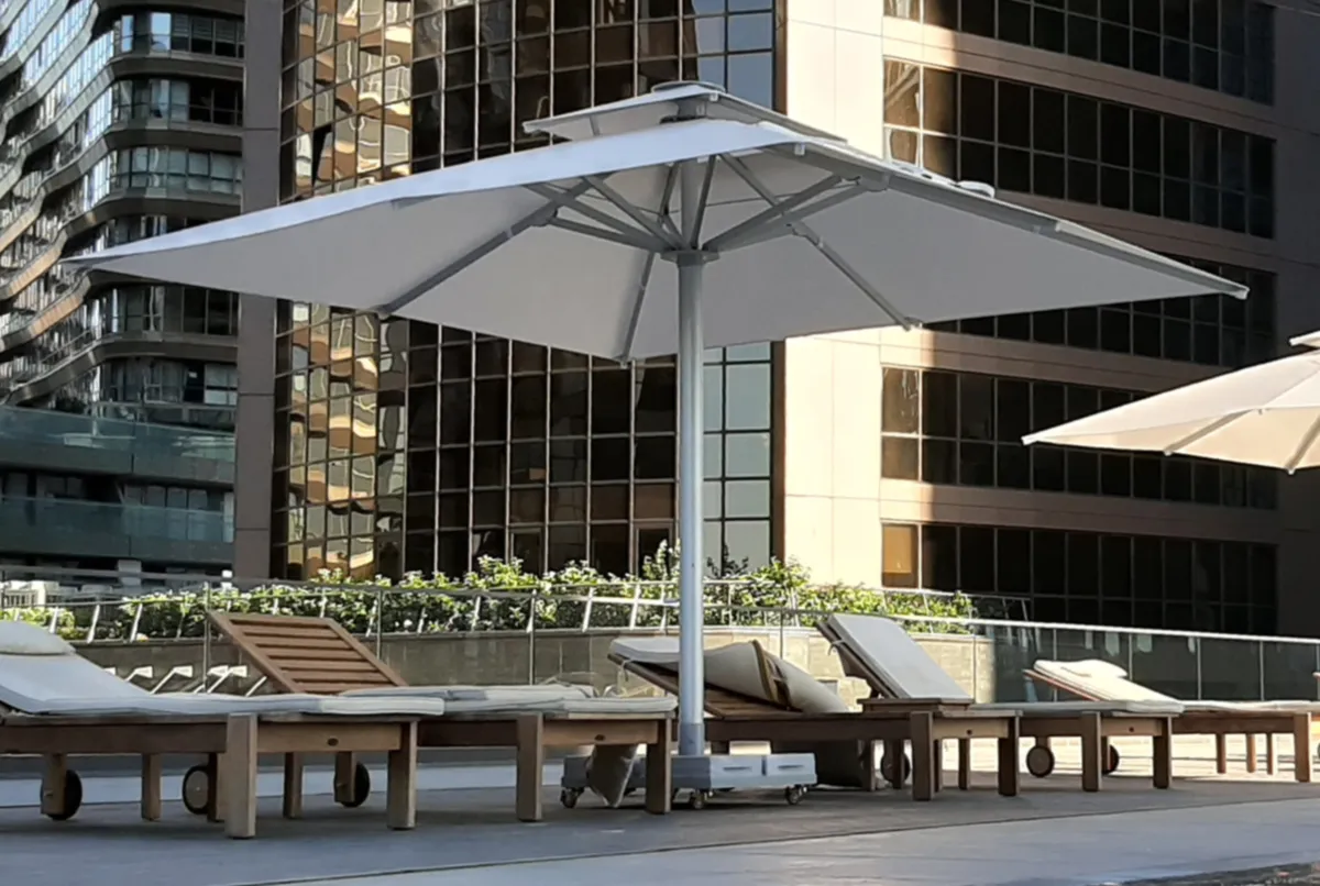 Großer heller Gastroschirm mit Teleskopmast an einer Hotelterrasse